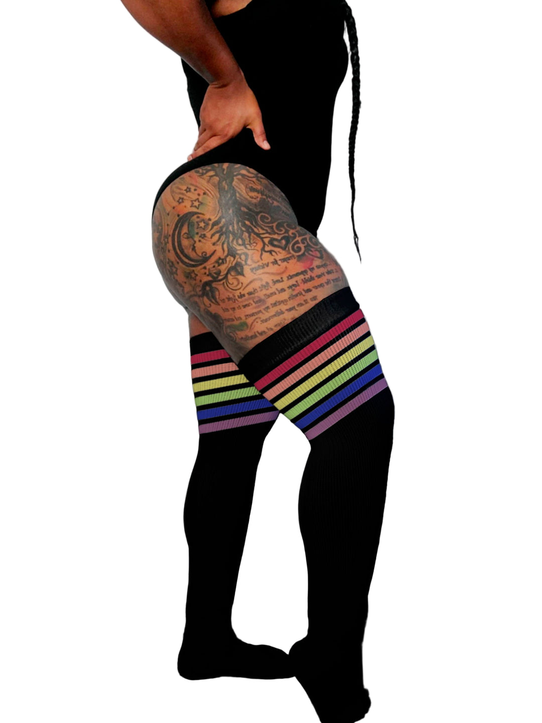 Person wearing black tights with rainbow stripes on a plain background